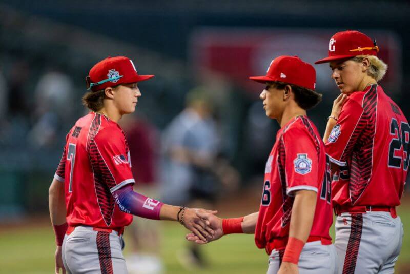Young baseball players on field shaking hands