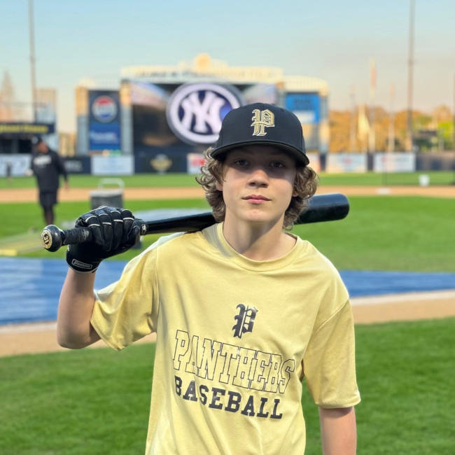 Young baseball player standing with bat on shoulder