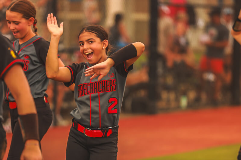 young softball players smiling on field