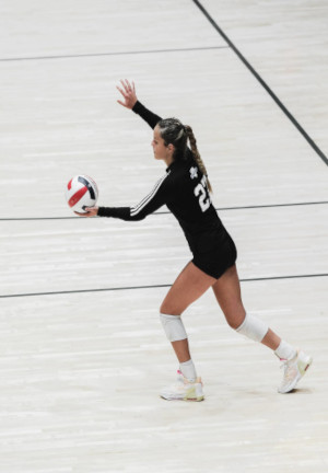young women serving a volleyball